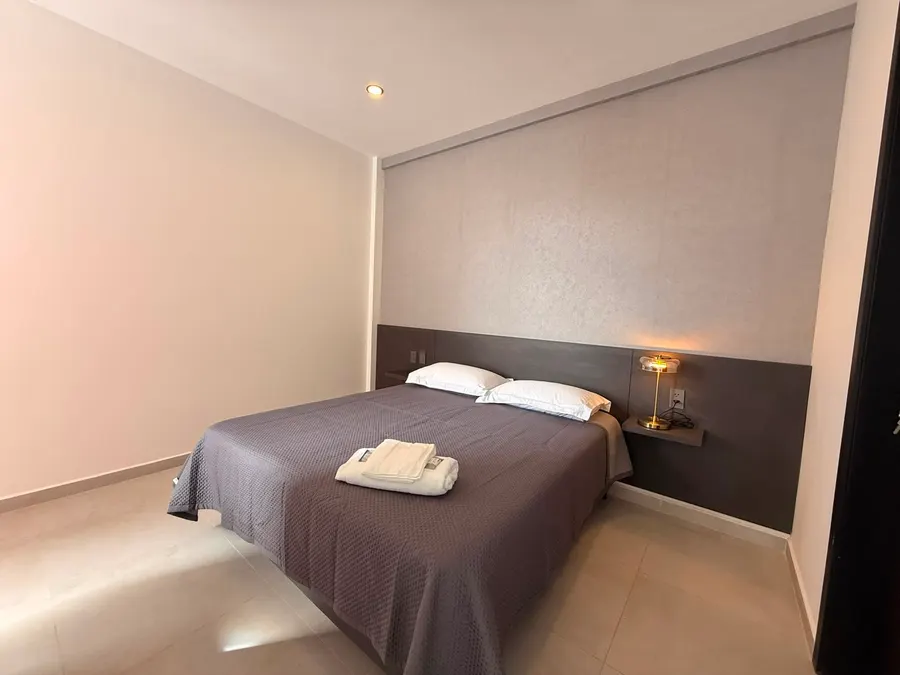 Dormitorio con cabecera y luz cálida