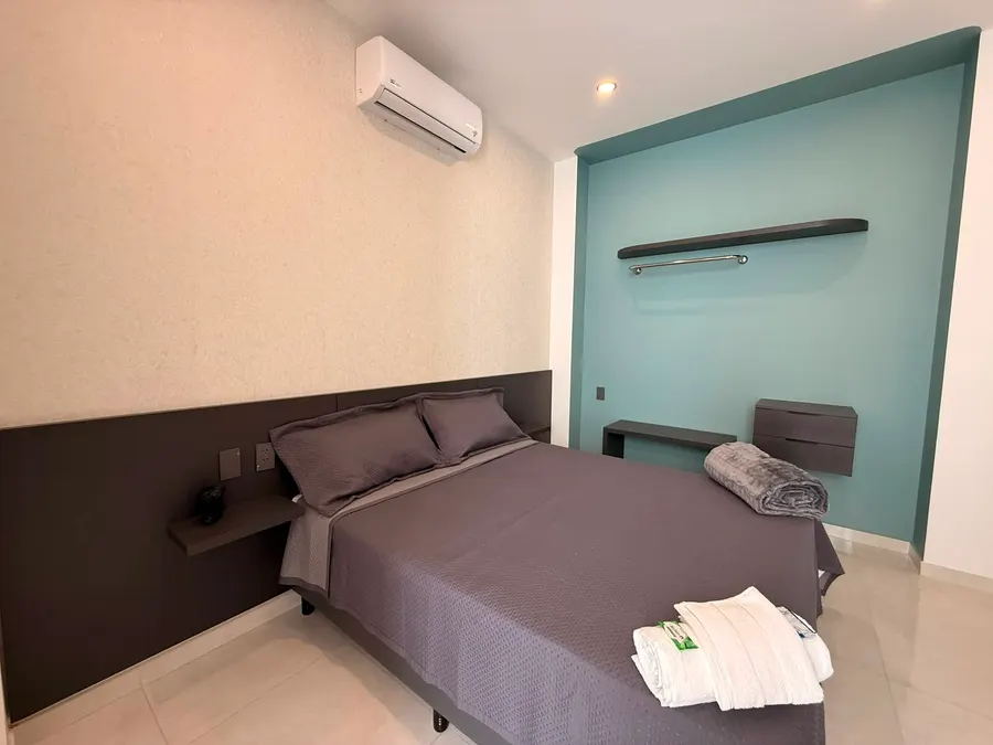 Dormitorio principal con cama de dos plazas y media y aire acondicionado