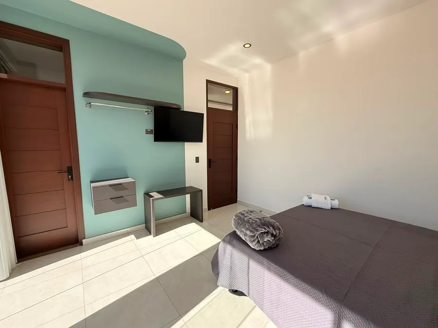 Segundo dormitorio con televisor y pared de acento